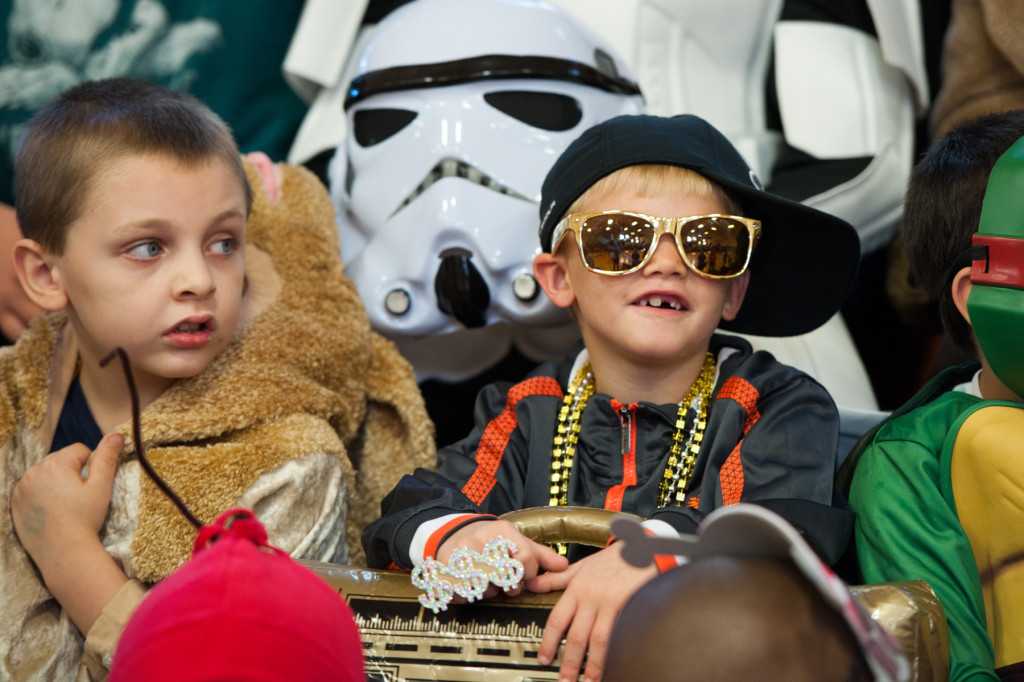 Chase Dunn (right) sits in the stands dressed up as a rapper with an inflatable boom-box as he and other students wait for the beginning of the Halloween Costume parade in the gymnasium of High Falls Elementary School on Friday, October 30, 2015 in Robbins, North Carolina.