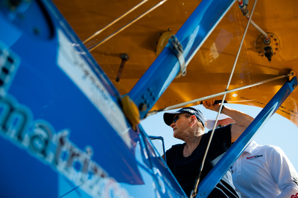 DeeDee Miller climbs into the co-pilot's seat at the front of Darryl Fisher's Boeing Stearman for her Ageless Aviation plane ride at the Moore County Airport on Tuesday, September 1, 2015 in Whispering Pines.