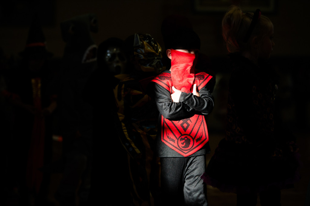 Bands of light stream across the students as they walk during the Halloween Costume parade in the gymnasium of High Falls Elementary School on Friday, October 30, 2015 in Robbins, North Carolina.
