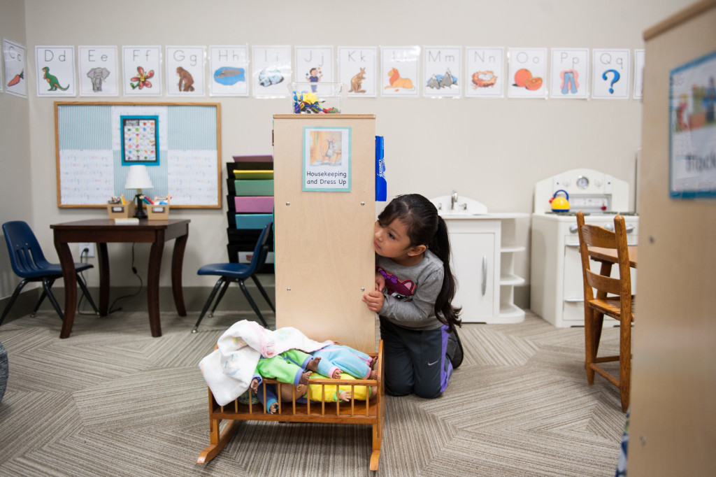 Jaidy Avila Parra peeks at her class during circle time in the toy kitchen area at HOPE Academy, a recently opened pre-school, on Wednesday, September 16, 2015 in Robbins, North Carolina.