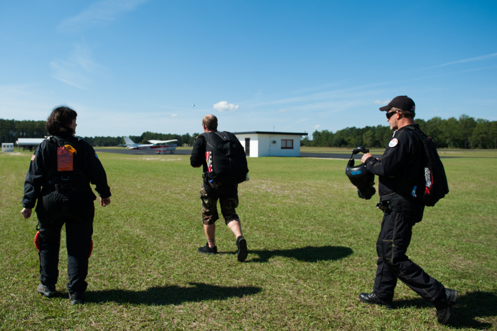 Tandem instructor Robbie Rushton (center) leads the group to their plane at the Raeford Drop Zone on Thursday, October 8, 2015 in Raeford, North Carolina.