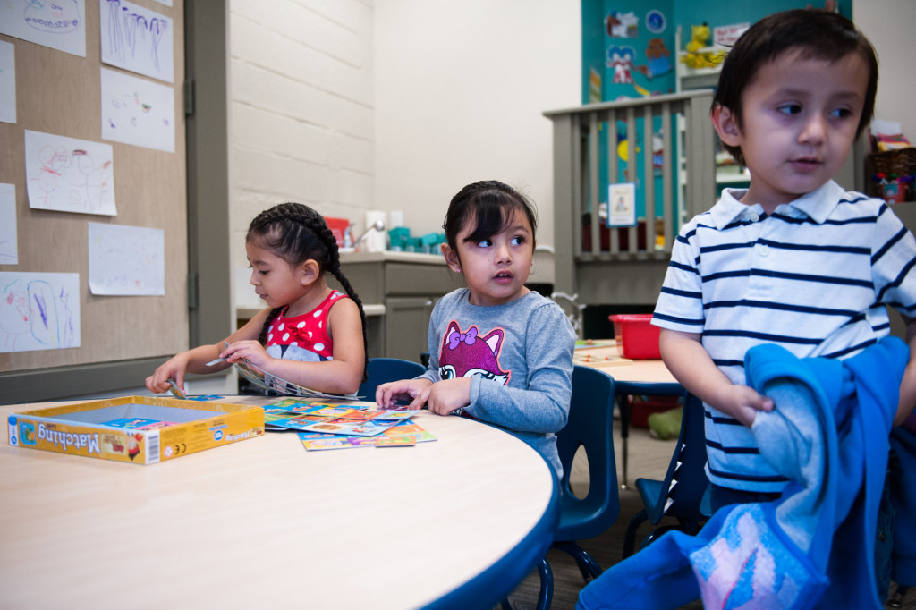 Julian Vargas takes off a sweater as Jaidy Avila Parra (center) and Hailey Prieto (left) play with puzzles at HOPE Academy, a recently opened pre-school, on Wednesday, September 16, 2015 in Robbins, North Carolina.